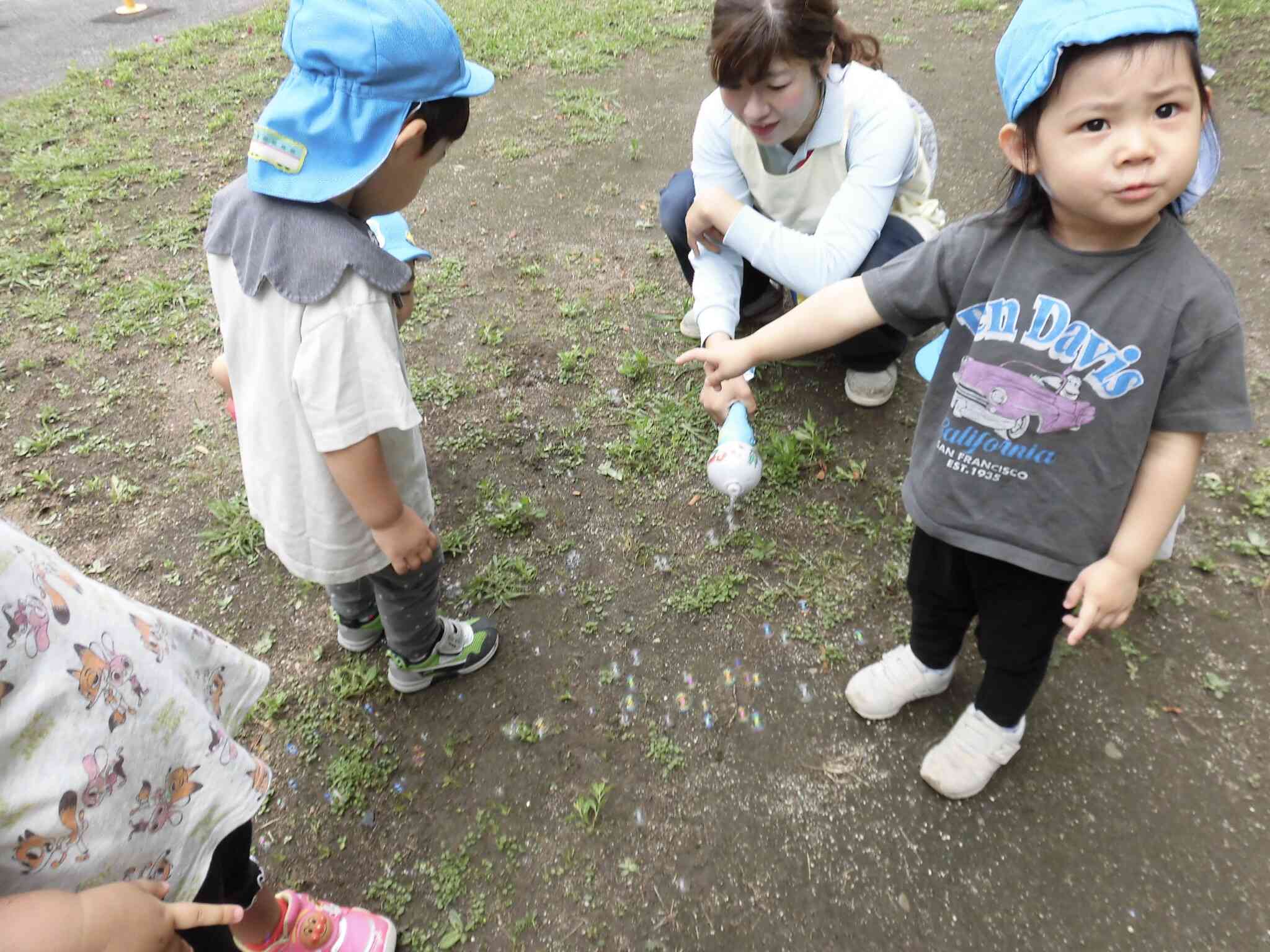濡れた地面にシャボン玉がつくのを楽しんで見ています!