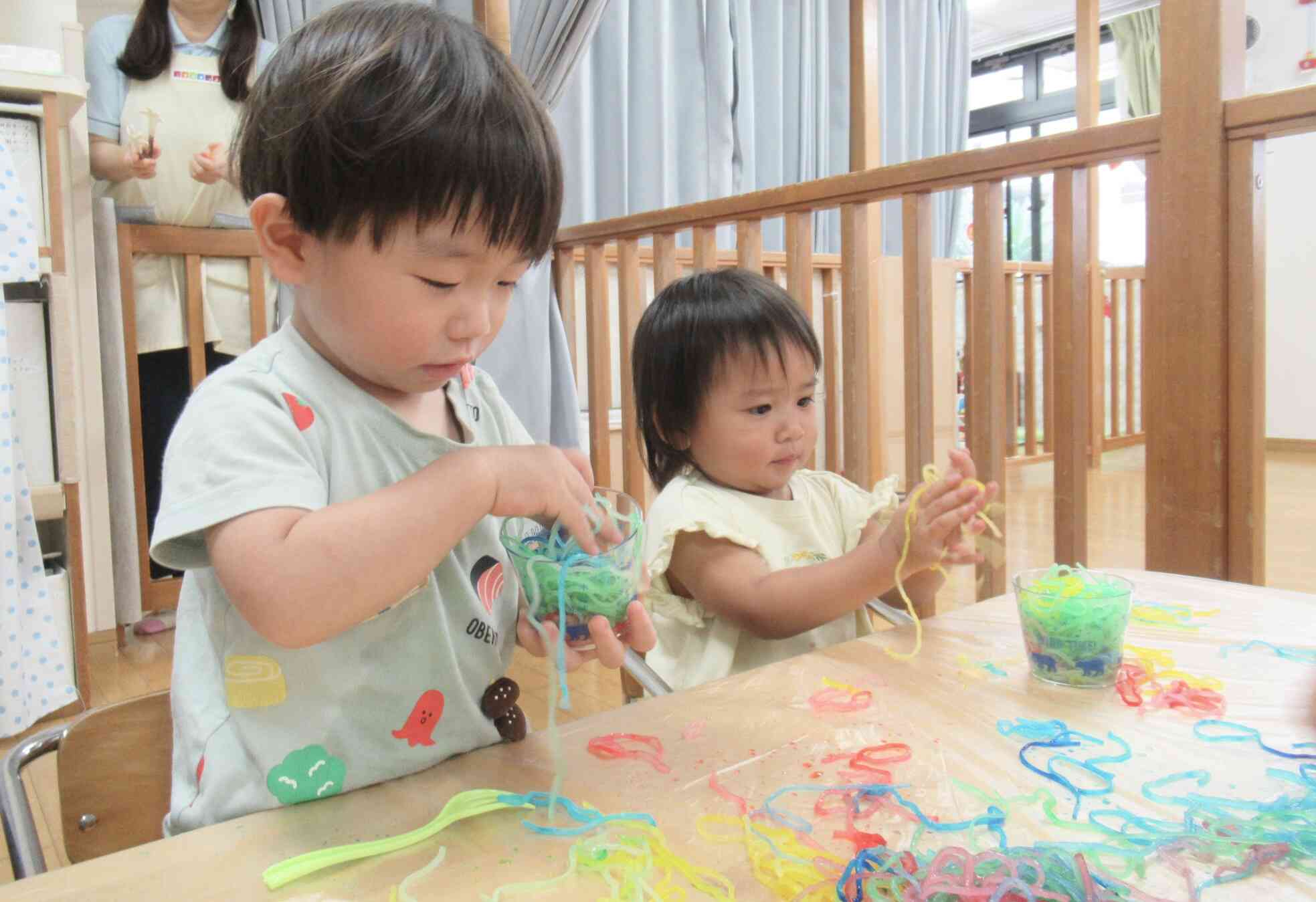 ぱんだ組(1歳児)さんもきりん組(2歳児)さんの真似をしてカップ入れに挑戦!