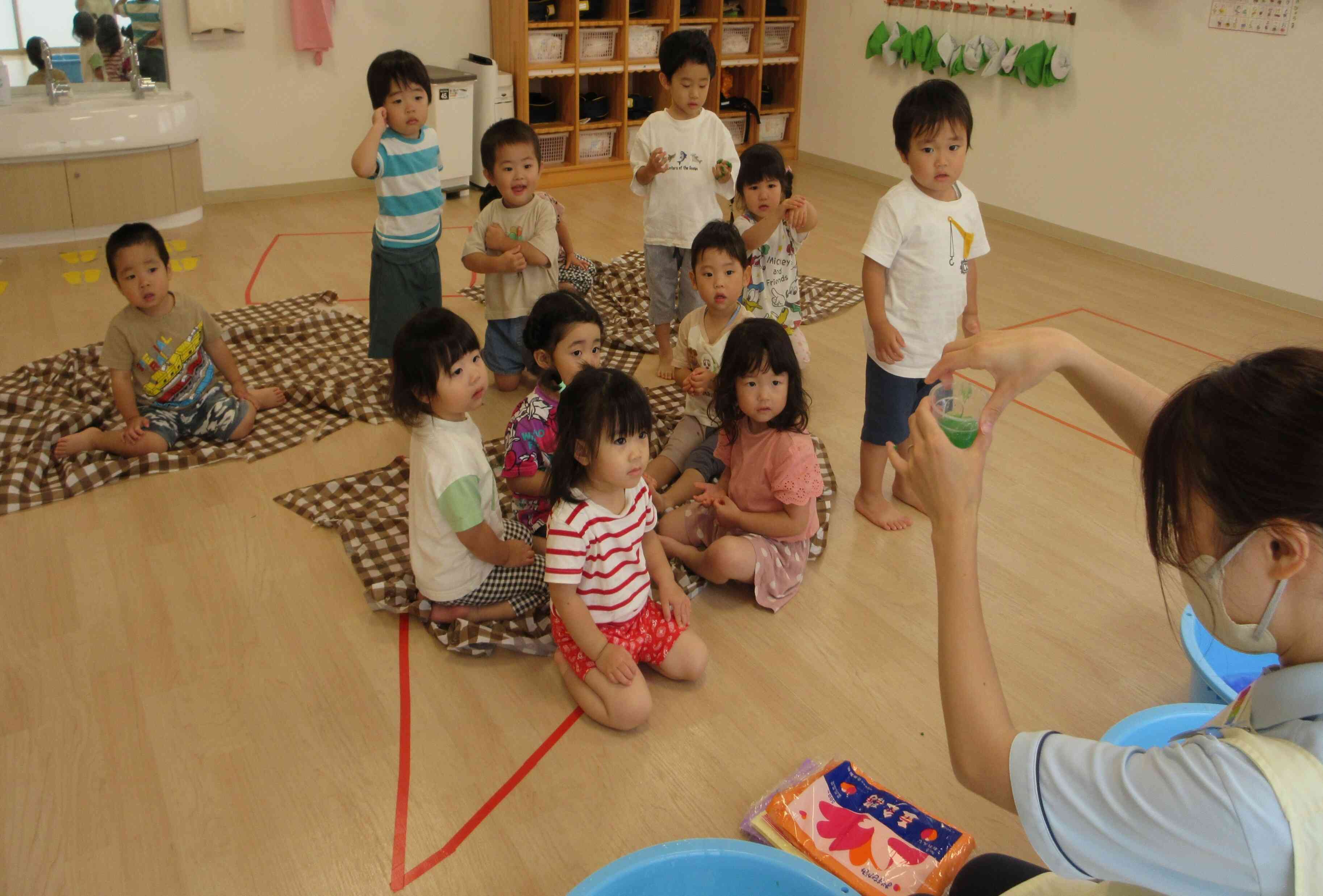 「何色になってる？」カップに出来た色水をすくってみんなにみせました。