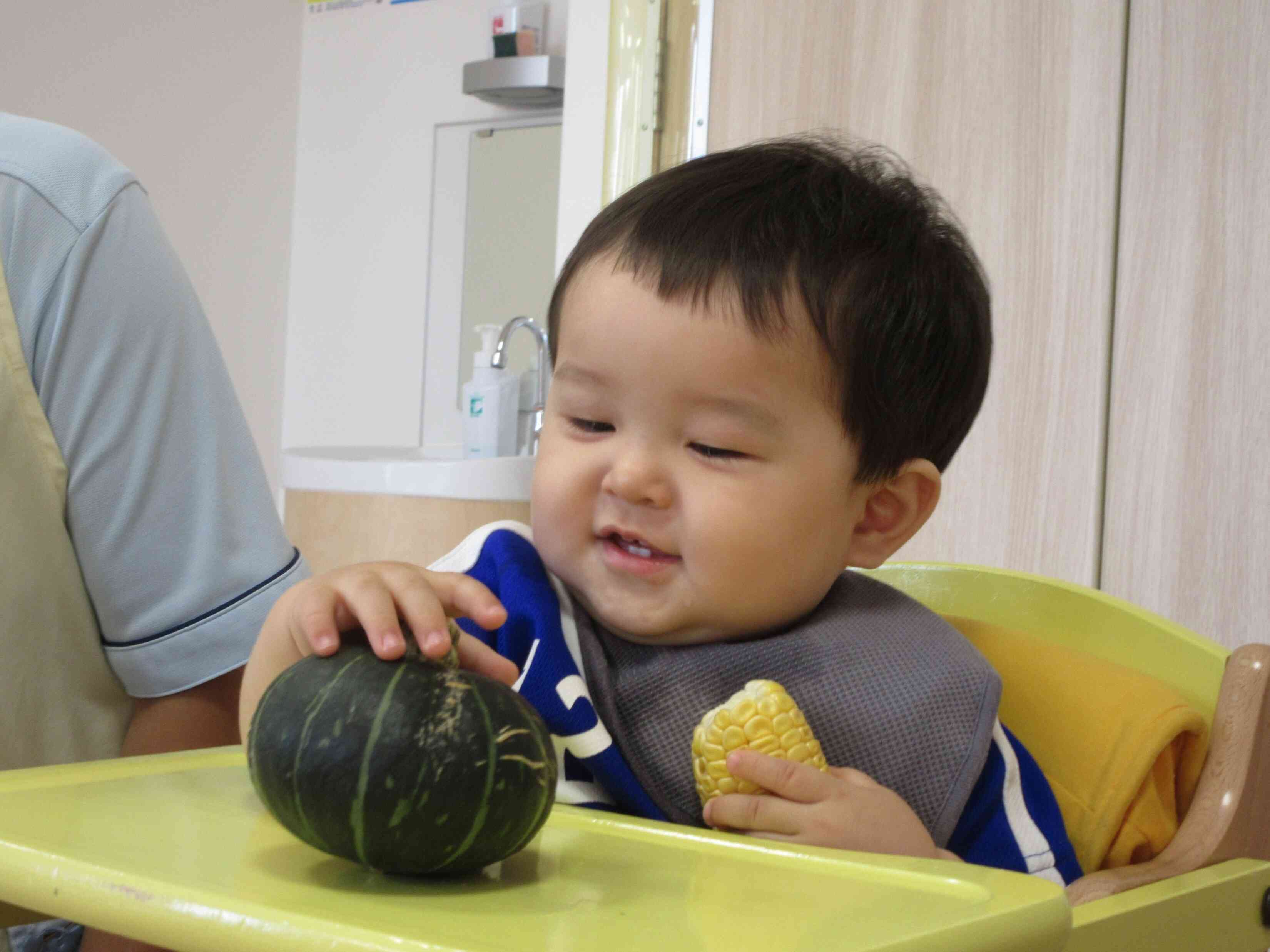 ０歳児は収穫野菜を触ったり香りを嗅いだり、よだれが止まりません。