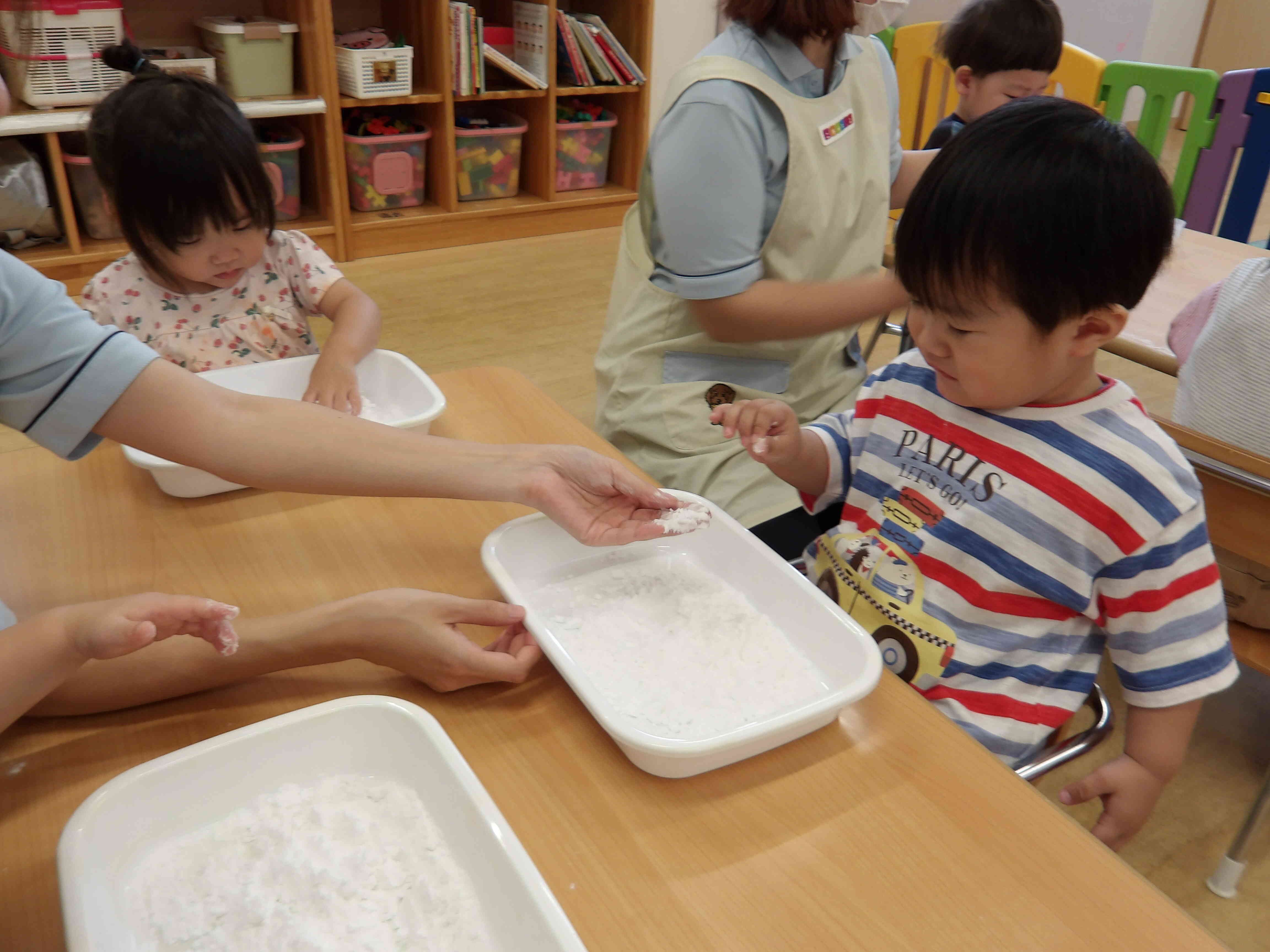 初めて片栗粉を使って感触遊びをしたMくん。不思議そうな表情を浮かべながらそっと手を伸ばしていました。