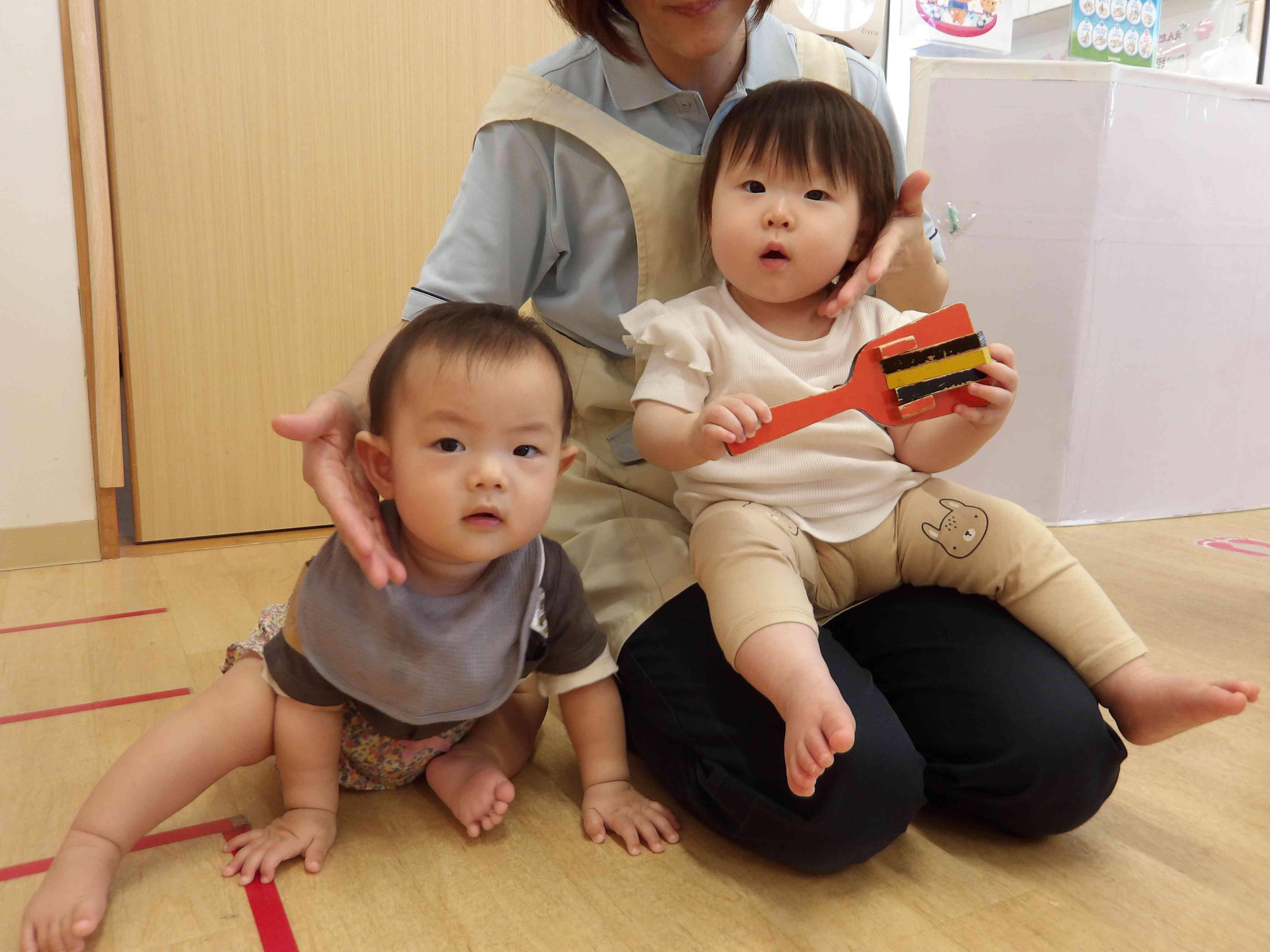 初めてのミュージックケア楽しいね！保育者に頬をツンツン。鳴子をシャカシャカ鳴らして嬉しそうなMちゃんとRちゃん。