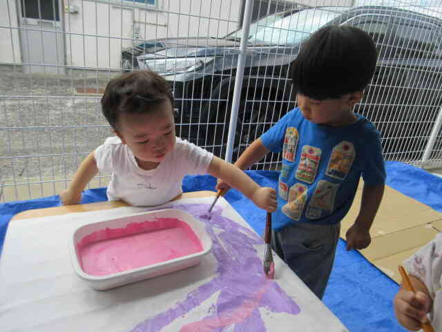 お友だちが塗った上から違う色で塗ってみると色が変わって不思議そうにするSくん。