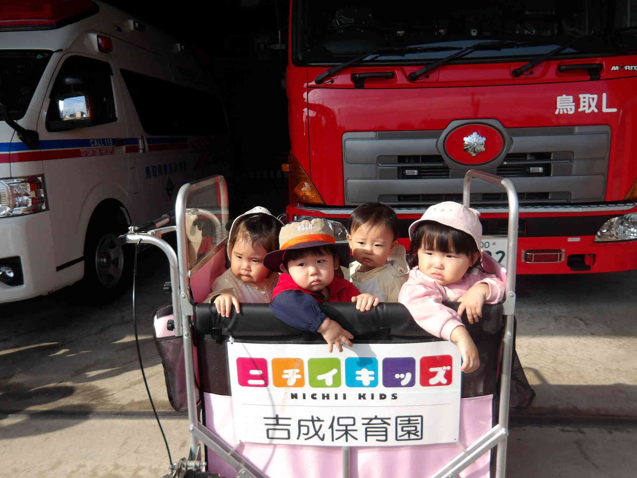 ハイチーズ！ひよこ組の高月齢の子どもたちで記念撮影。消防車見れてよかったね