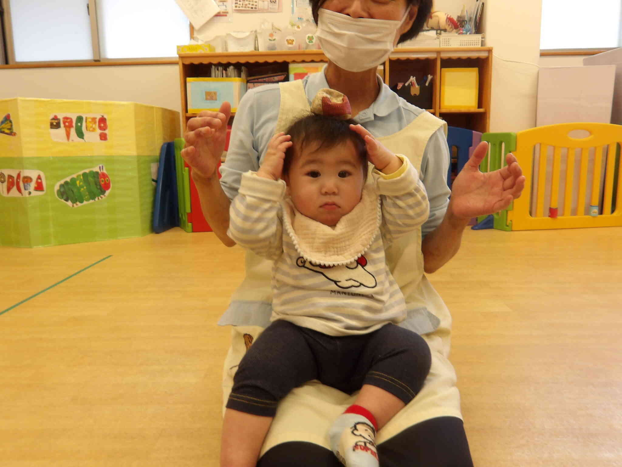 餅つきぺったんこの手遊びの歌に合わせてお手玉を頭にのせるとどこいった？と手を挙げて探していたＮちゃんです。