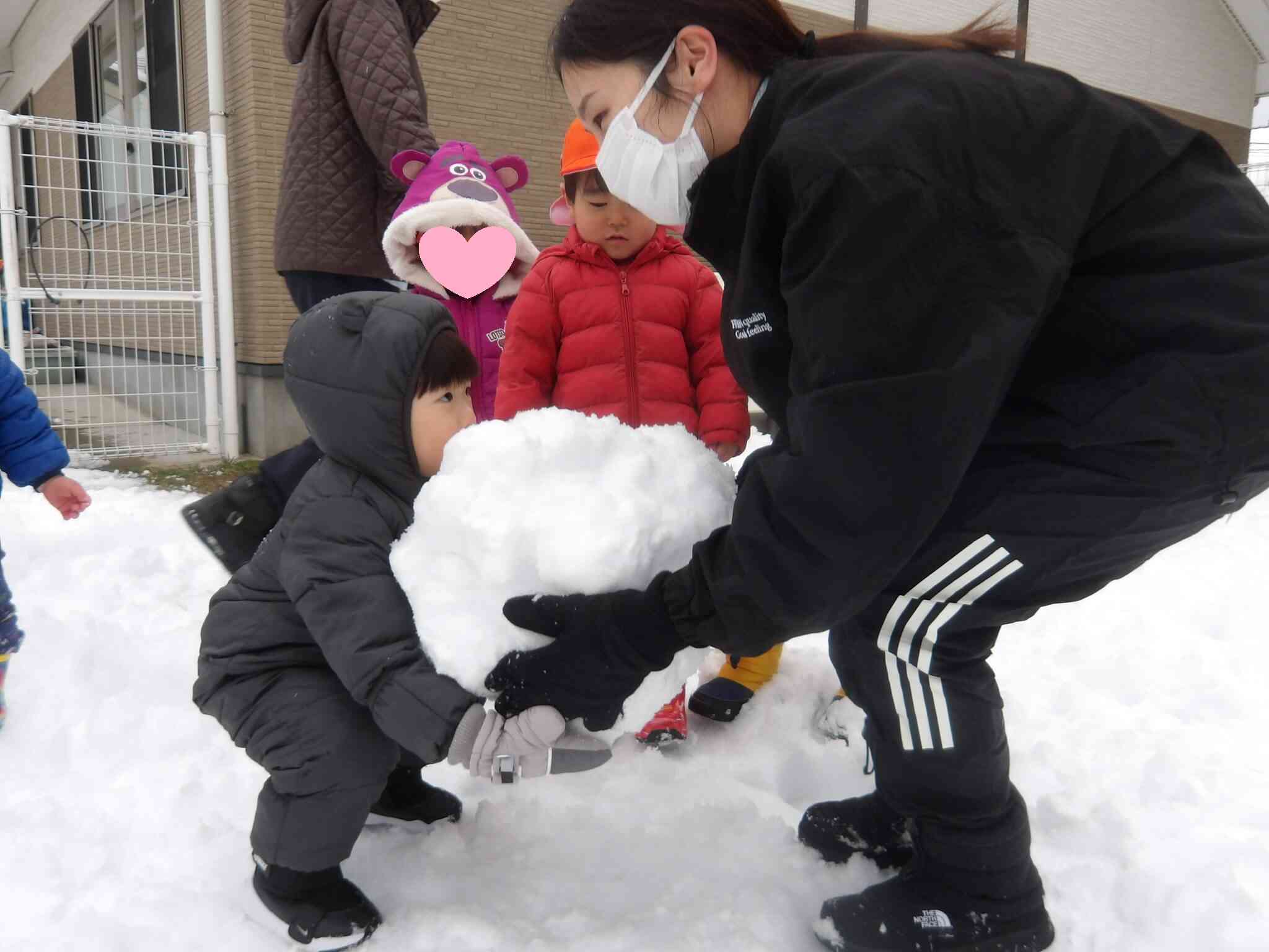 保育者と一緒に雪だるまの頭を「よいしょ」と持ちあげて完成していました！