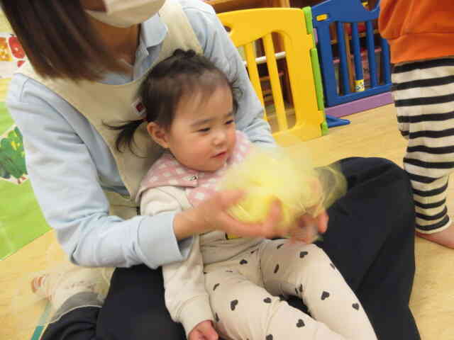 “お花がわらった”の曲に合わせて保育者がオーガンジーのお花を咲かせると「あっは～！」と喜ぶRちゃんです。