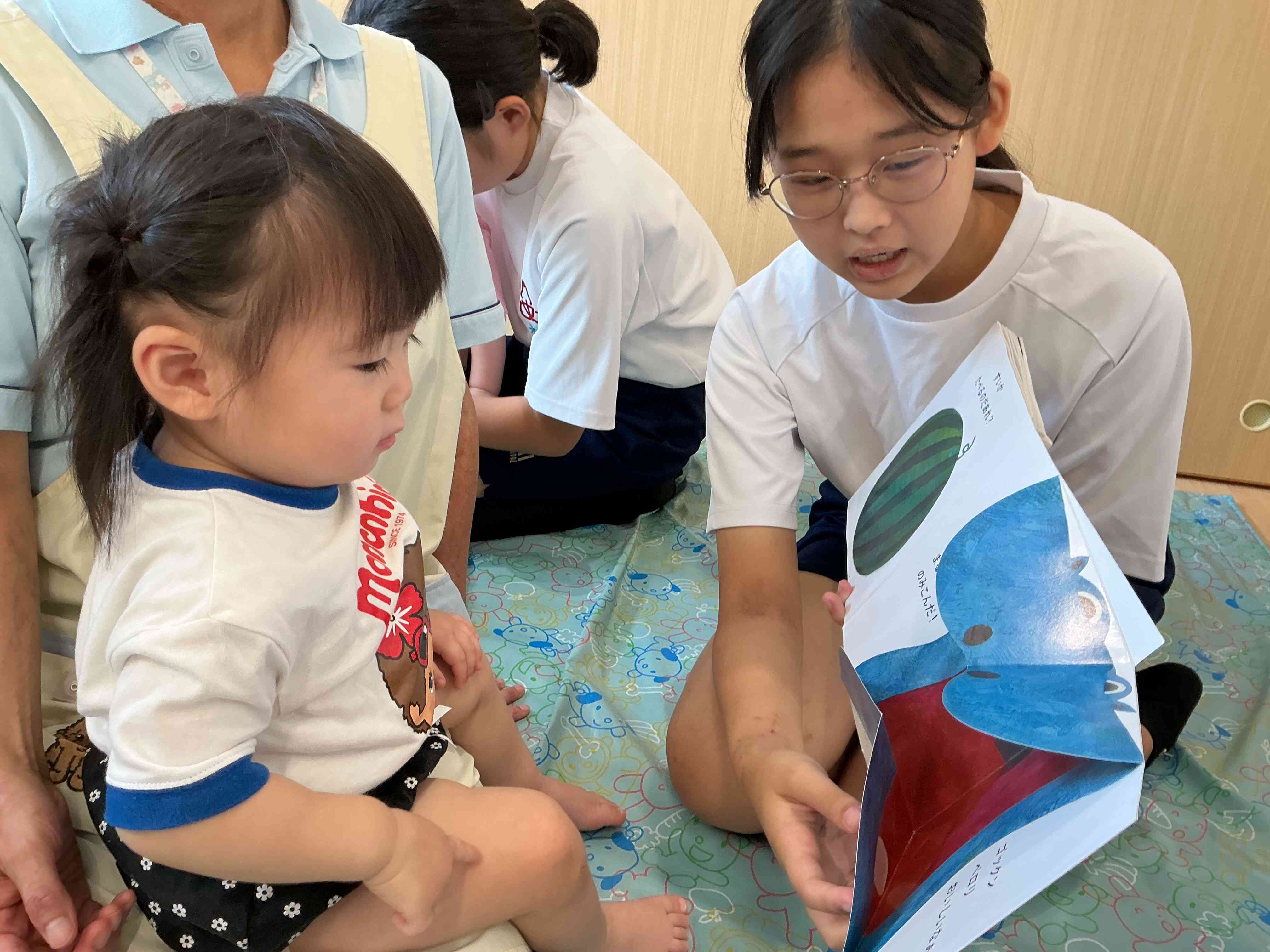 大好きな絵本を読んでもらい、真剣に見ているひよこ組のNちゃんです。