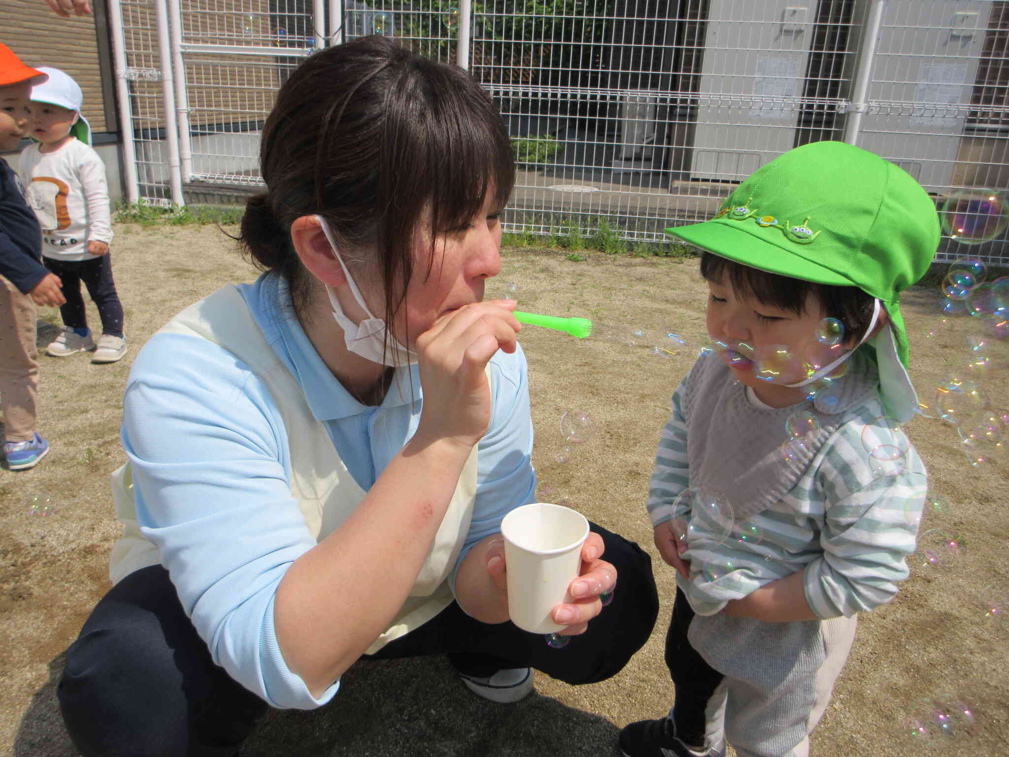 先生が吹いてくれたしゃぼん玉を不思議そうに見つめるR君