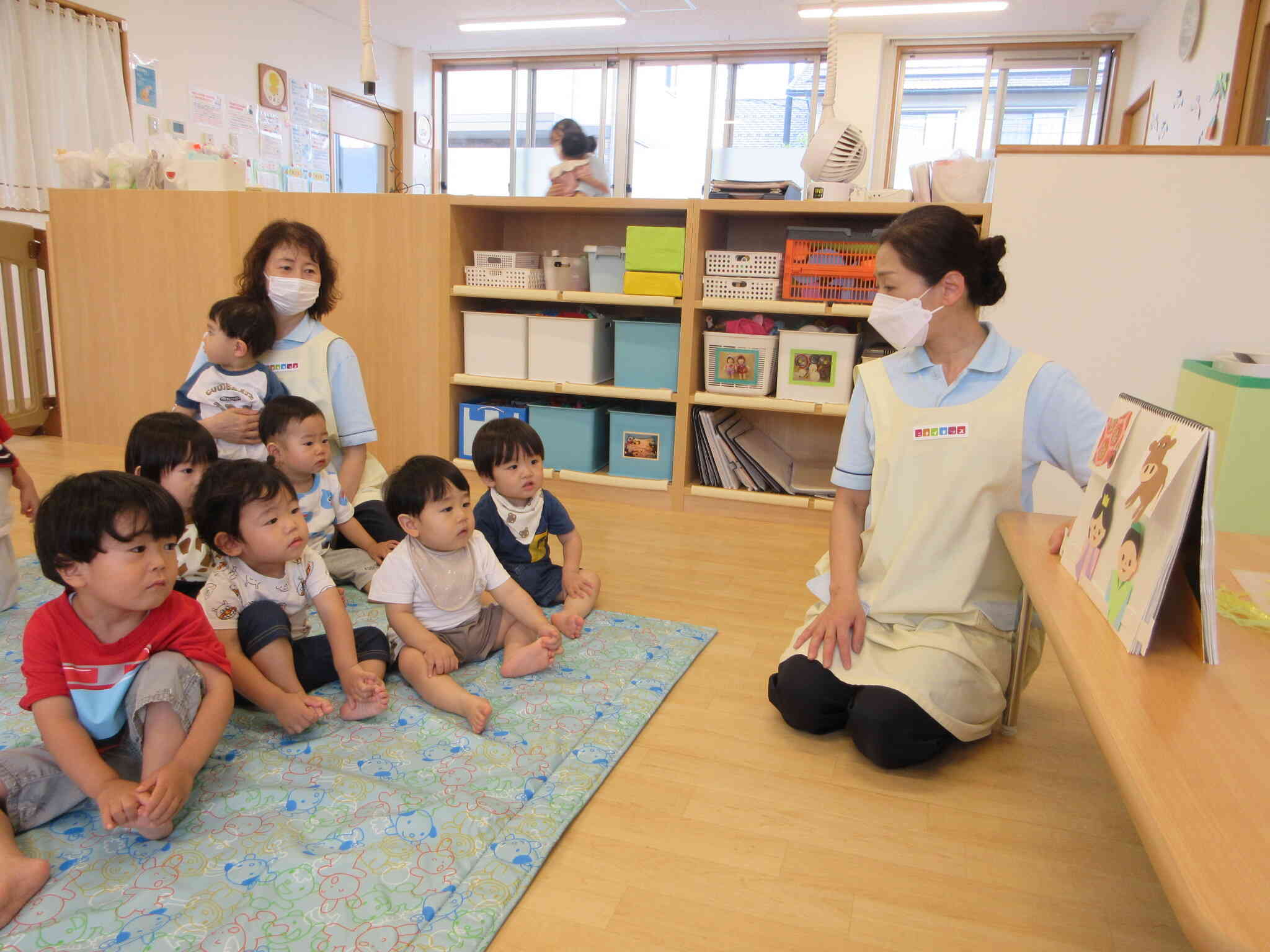真剣なまなざしでスケッチブックシアターをみている子どもたち。