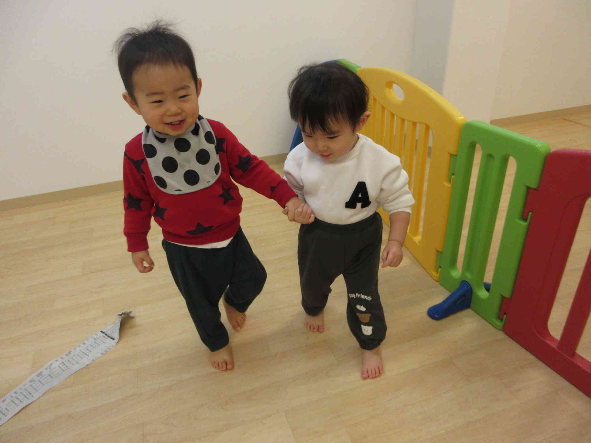 仲良く手を繋いでたくさんの新聞紙の上をお散歩に行くKくんとAくん。