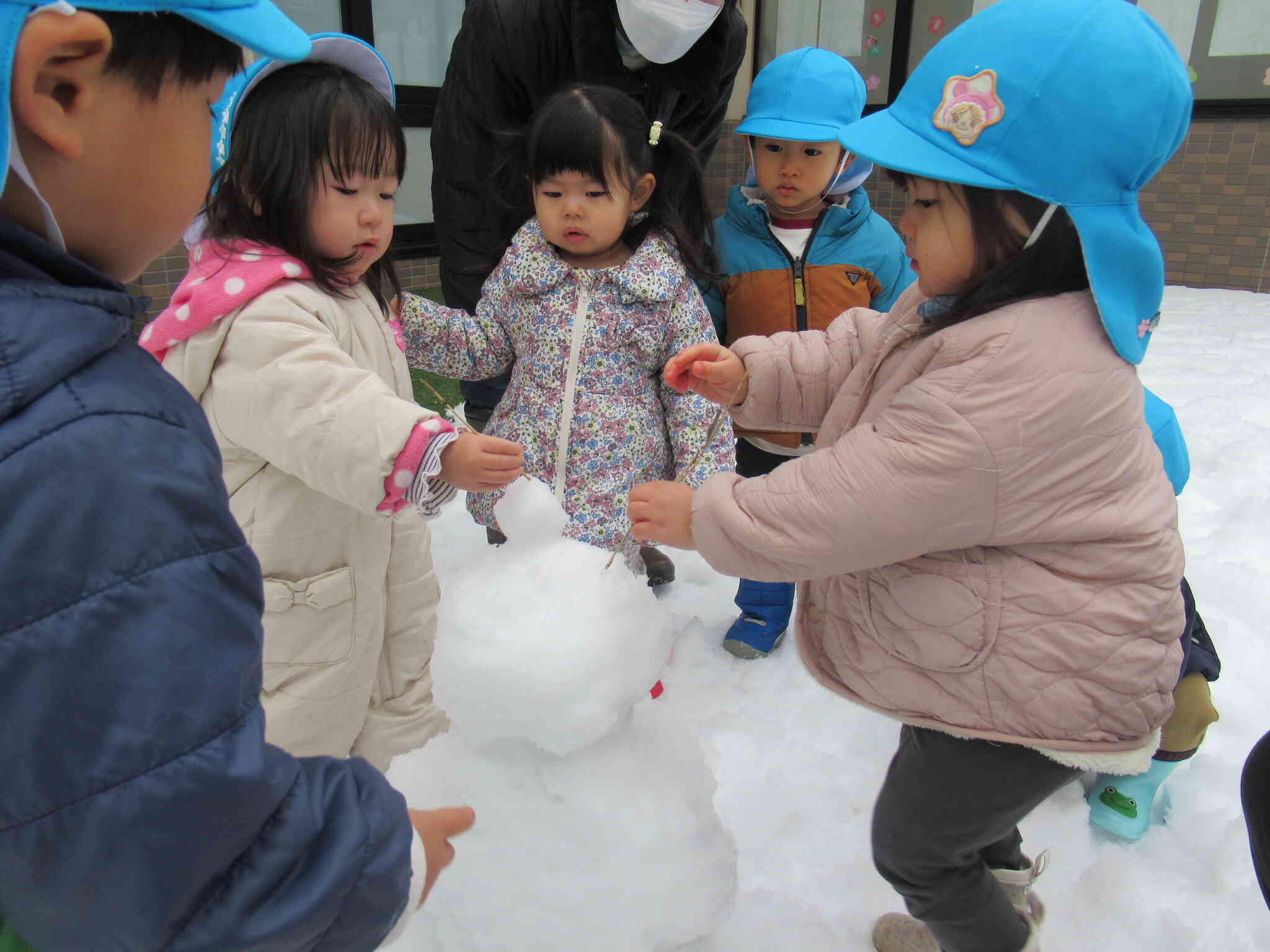 「耳もつけよう」「目はどうする？」と相談しあう子どもたち